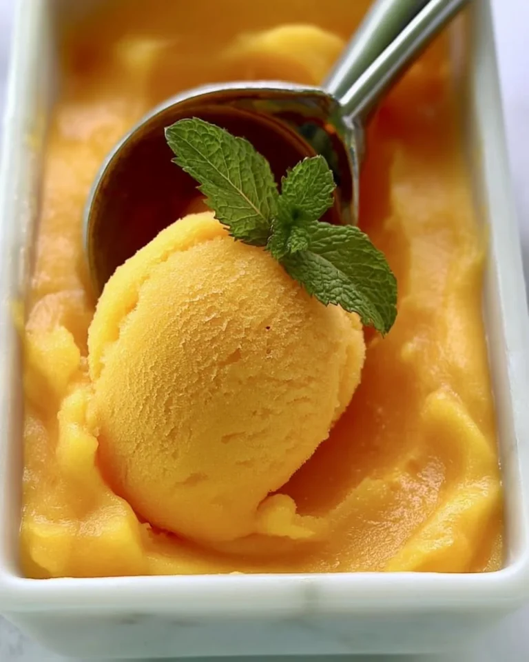 Homemade peach sorbet with fresh peaches served in a bowl