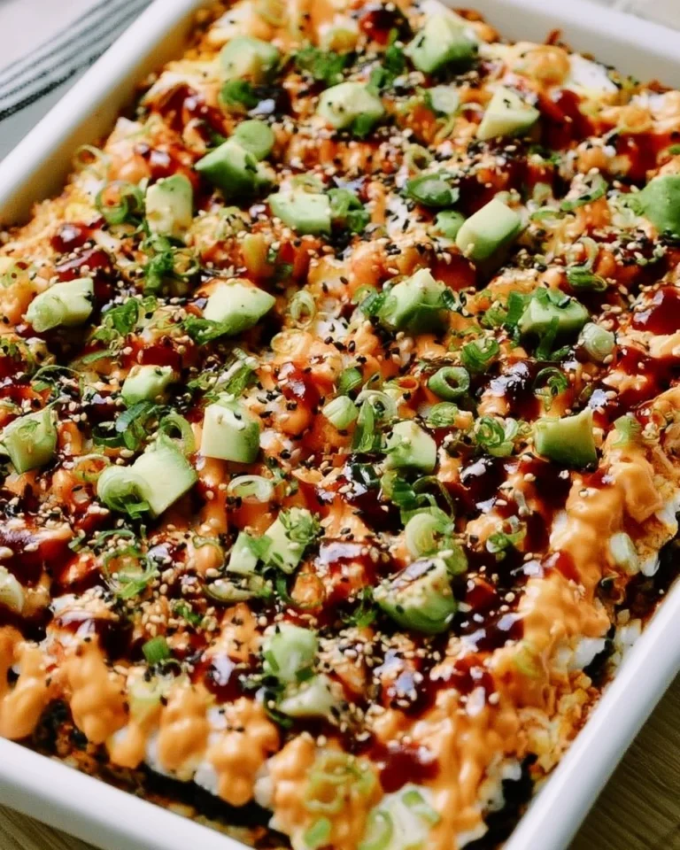 Delicious Easy Sushi Bake topped with shrimp and avocado, served in a baking dish.