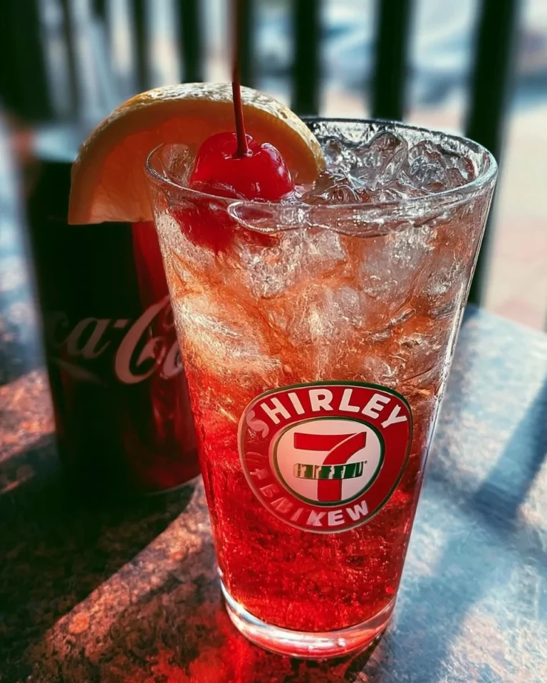A refreshing Shirley Temple drink with cherry and orange garnish.