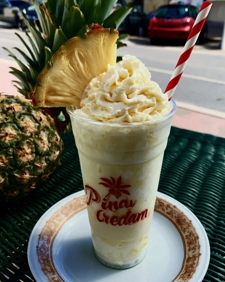 A refreshing Pina Colada Dream cocktail garnished with pineapple and cherry